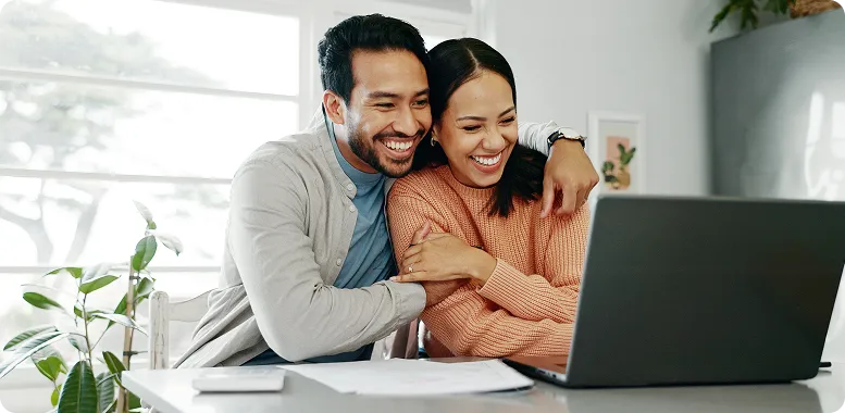 Couple using a computer together hugging - mortgage calculators