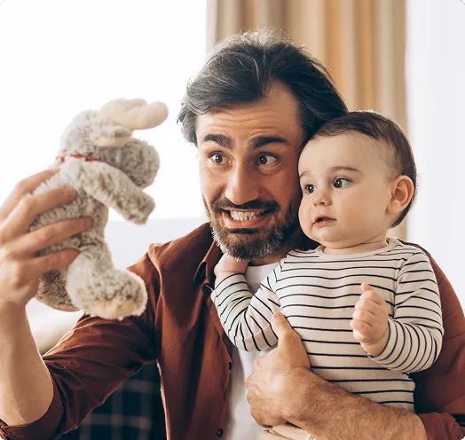 Father holding baby with stuffed animal