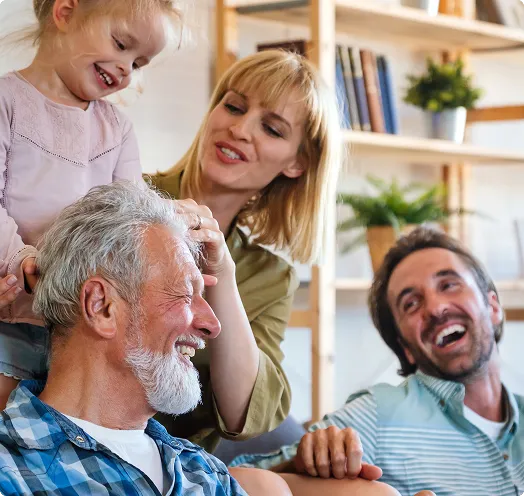 Family sitting on a couch laughing - First time home owners