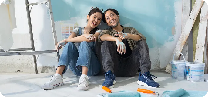 Couple sitting side by side working on home renovation - Home Equity Loan