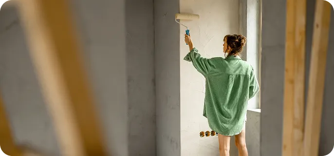 Woman painting walls inside of home
