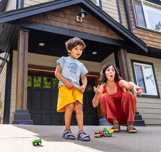 Mother and son standing in front of home