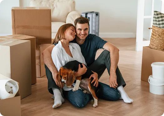 Couple sitting on the floor with pet dog